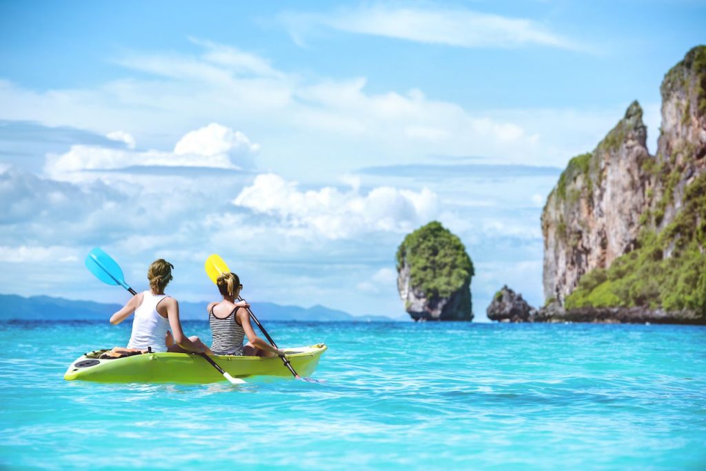 Two-ladies-are-kayaking-or-kanoeing-at-beautuful-tropical-lagoon-at-Phi-Phi-islands